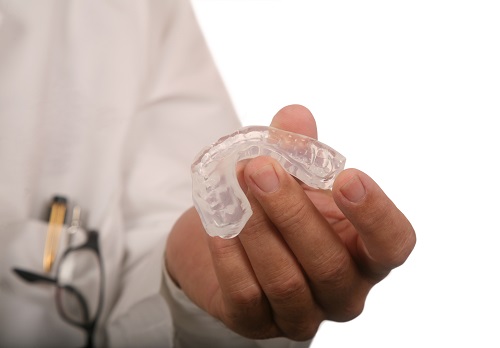 A dentist holding a mouthguard at Greashaber Dentistry in Ann Arbor, MI