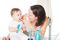 Baby brushing teeth after visiting Greashaber Dentistry in Ann Arbor, MI